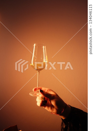 Elegant Hand Holding Sparkling Golden Drink Elegant Hand Holding Sparkling Golden Drink 134046115