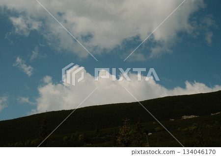Green Hillside Beneath Dramatic Summer Clouds Green Hillside Beneath Dramatic Summer Clouds 134046170
