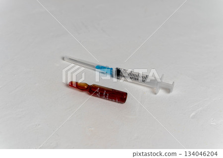 Syringe and medicine vial placed on a smooth surface in a clinical setting Syringe and medicine vial placed on a smooth surface in a clinical setting 134046204