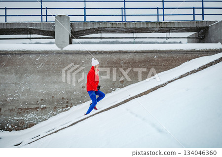 Winter workout for senior woman in snowy city. 134046360