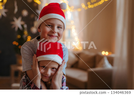 Children wearing Santa hats smiling at Christmas. 134046369