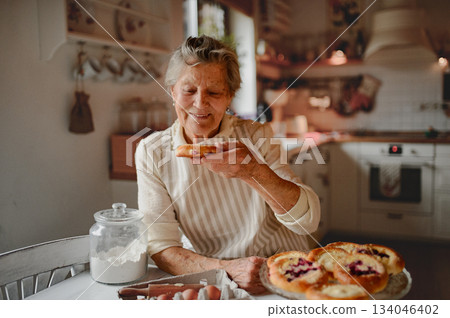 Grandmother eating homemade sourdough cakes. Grandmother eating homemade sourdough cakes. 134046402