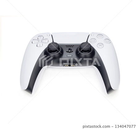 A white and black PS5 controller. The gamepad is sitting on a white surface A white and black PS5 controller. The gamepad is sitting on a white surface 134047077