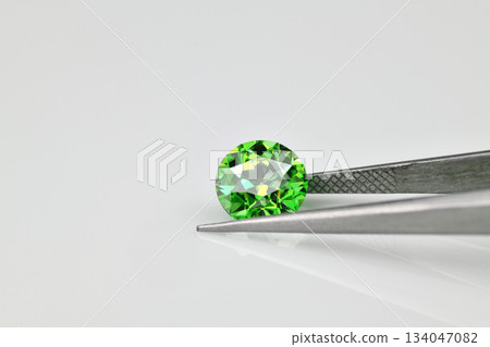 A green gemstone is on a white background A green gemstone is on a white background 134047082