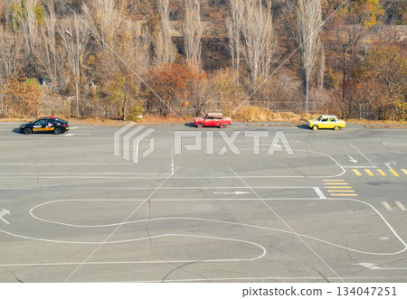 Yerevan Armenia 10.25.2025. A parking lot with three cars, one of which is yellow Yerevan Armenia 10.25.2025. A parking lot with three cars, one of which is yellow 134047251