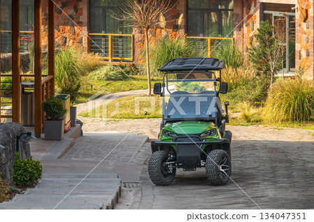 Yerevan Armenia 10.25.2025. A green golf cart is parked in front of a building Yerevan Armenia 10.25.2025. A green golf cart is parked in front of a building 134047351