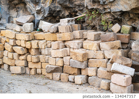 A pile of bricks is stacked up against a wall A pile of bricks is stacked up against a wall 134047357