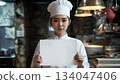 Japanese female chef holding up a white piece of paper 134047406