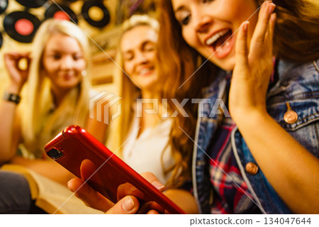 Girl in pub using smart phone Girl in pub using smart phone 134047644