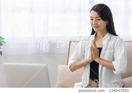 一名女子在筆記型電腦前冥想 134047693