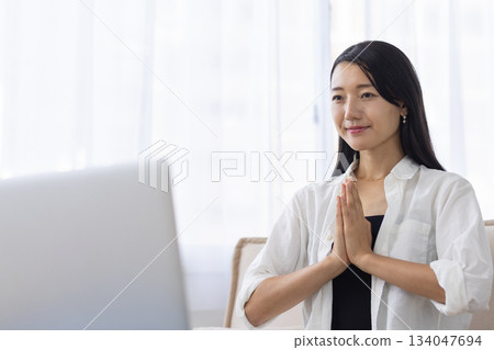 一名女子在筆記型電腦前冥想 134047694