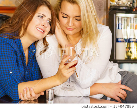 Sad woman crying and being consoled by friend. 134047899