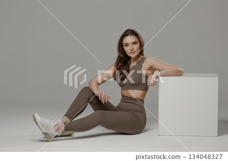 Model poses in stylish activewear against a neutral background showcasing fitness and fashion Model poses in stylish activewear against a neutral background showcasing fitness and fashion 134048327