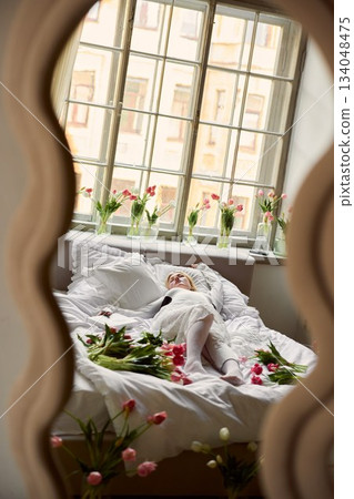 Elegant floral scene, Dreamlike aesthetic capturing woman draped in lace with blooming tulips and gentle glow 134048475