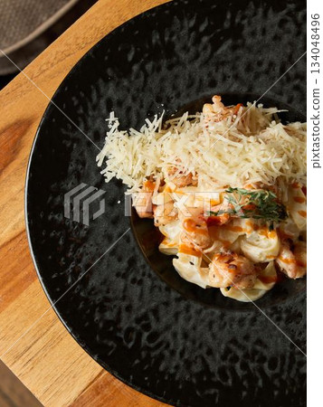 Delicious shrimp served with rich sauce, Savory shrimp resting on cheesy bed with parmesan toppings 134048496