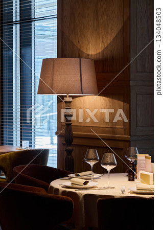 comfortable table by window light, intimate corner with gentle lighting and tasteful dining accessories comfortable table by window light, intimate corner with gentle lighting and tasteful dining accessories 134048503