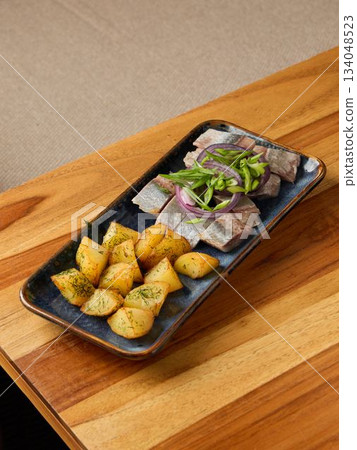 Cozy dinner presentation highlighting seared tuna with golden roasted potatoes on rustic surface Cozy dinner presentation highlighting seared tuna with golden roasted potatoes on rustic surface 134048523