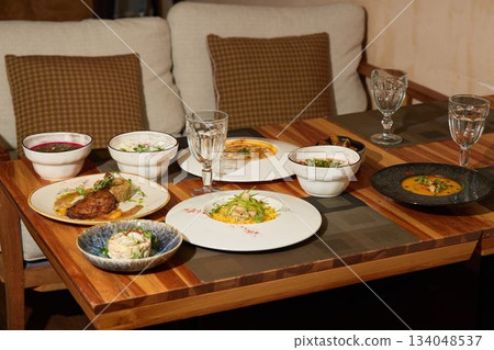 Enjoy a Gourmet Dining Experience with an Array of Diverse Dishes at a Cozy Table Setting 134048537