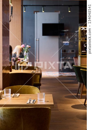 Sleek restaurant with preparation area, Stylish restaurant with visible cooking stations and cozy ambiance Sleek restaurant with preparation area, Stylish restaurant with visible cooking stations and cozy ambiance 134048541