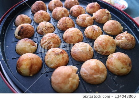 Close-up shot of takoyaki cooking on a takoyaki plate 134048800