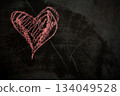 Chalk a heart on a dark surface for digital Valentine's Day content. 134049528