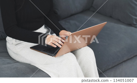 A woman using a laptop computer in the room 134051007