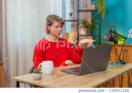 Woman emotionally arguing with laptop screen, gesturing angrily, irritated frustrated disagreement Woman emotionally arguing with laptop screen, gesturing angrily, irritated frustrated disagreement 134051180