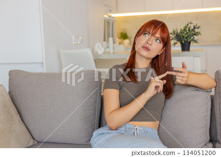 Young woman counts tasks on fingers folds digits tallies list with focus and nods thoughtful rhythm 134051200