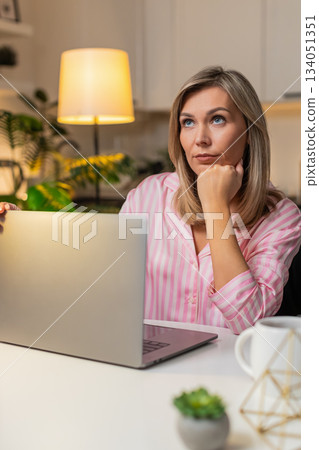 Adult woman freelancer tired powers off laptop closes lid decides to continue tomorrow focused fresh Adult woman freelancer tired powers off laptop closes lid decides to continue tomorrow focused fresh 134051351