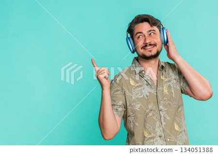 Adult man enjoying music in headphones rhythmically moving head expressing satisfaction dancing 134051388