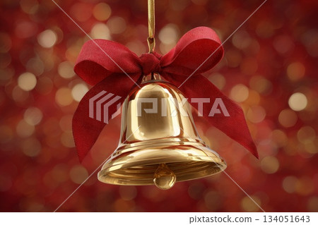 Golden Christmas bell with red ribbon against a festive bokeh background for holiday decoration 134051643