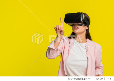 Woman wearing VR headset moving hands in air excited amazed virtual reality immersive digital world 134051983