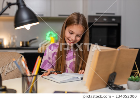 Teenager girl serious homework solves tasks from book writes notes in notebook deep focus study math Teenager girl serious homework solves tasks from book writes notes in notebook deep focus study math 134052000