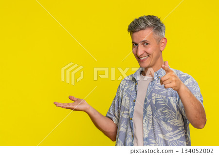 Adult man pointing at camera and then to empty side space suggesting action promoting advertisement Adult man pointing at camera and then to empty side space suggesting action promoting advertisement 134052002