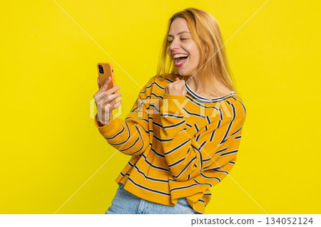 Happy excited winner woman use smartphone celebrating success winning play game good lottery news 134052124