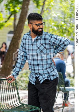 Indian mature man touching injured sore back backache suffering lower lumbar discomfort muscle pain Indian mature man touching injured sore back backache suffering lower lumbar discomfort muscle pain 134052129