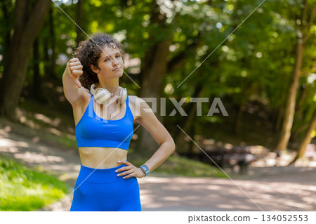 Upset sportswoman showing thumbs down dislike gesture expressing discontent disapproval dissatisfied Upset sportswoman showing thumbs down dislike gesture expressing discontent disapproval dissatisfied 134052553