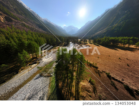 Aerial drone view of a gorge overlooking a forest and a mountain river surrounded by tree-covered cliffs. A sunny day in the high mountains Aerial drone view of a gorge overlooking a forest and a mountain river surrounded by tree-covered cliffs. A sunny day in the high mountains 134053048