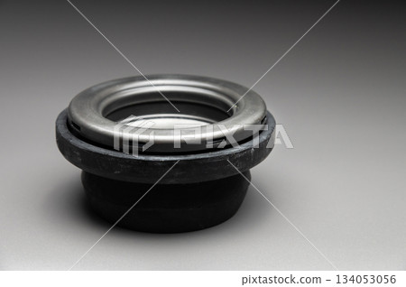 A new two-piece front strut support bearing. The new part is shown on a black gradient background. A new two-piece front strut support bearing. The new part is shown on a black gradient background. 134053056