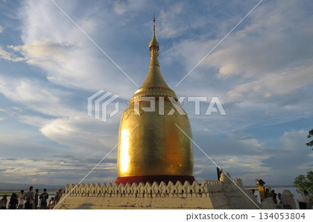 A gold pagoda on the banks of the Irrawaddy River at Sunset in Bagan 134053804