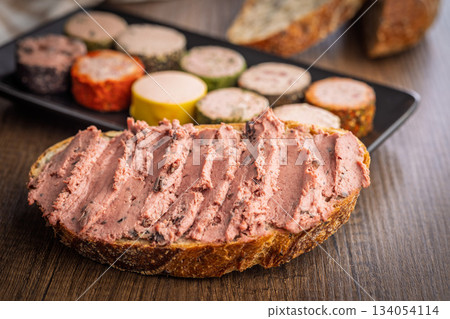 Pate on a slice of bread on wooden table. Pate on a slice of bread on wooden table. 134054114