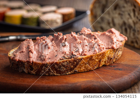 Pate on a slice of bread on wooden table. 134054115