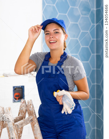 Portrait of a young woman tiler in the bathroom Portrait of a young woman tiler in the bathroom 134054666