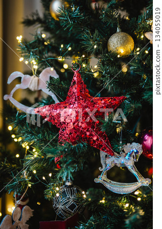Holiday background, Christmas red, star decoration on Christmas tree, copy space Holiday background, Christmas red, star decoration on Christmas tree, copy space 134055019
