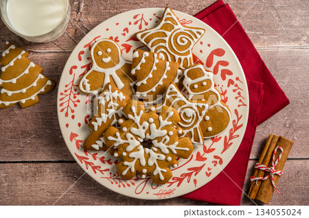 Holiday background. Christmas gingerbread cookies in different shapes in a plate Holiday background. Christmas gingerbread cookies in different shapes in a plate 134055024