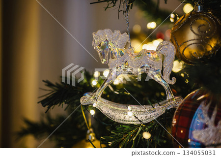 Holiday background, Christmas horse transparent, crystal decoration on Christmas tree, copy space Holiday background, Christmas horse transparent, crystal decoration on Christmas tree, copy space 134055031