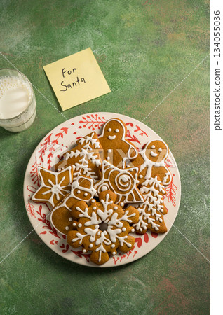 Holiday background. Christmas gingerbread cookies for Santa, with a sticky note. Flat lay Holiday background. Christmas gingerbread cookies for Santa, with a sticky note. Flat lay 134055036