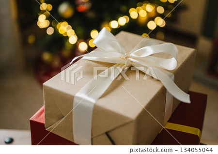 Holiday background, gift boxes next to Christmas tree. Abstract Christmas background, lifestyle. Copy space 134055044
