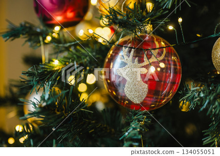 Holiday background. Beautiful Christmas red bauble decoration on Christmas tree, copy space 134055051