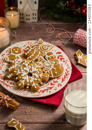 Holiday background. Christmas gingerbread cookies in different shapes in a plate Holiday background. Christmas gingerbread cookies in different shapes in a plate 134055063